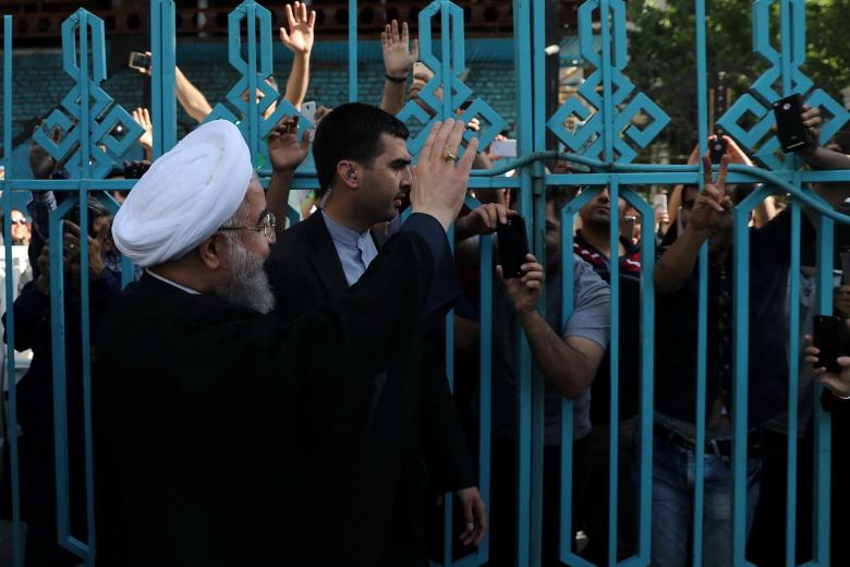 Iran's President Hassan Rouhani waves to supporters at a polling station during the presidential election in Tehran, Iran, May 19, 2017.