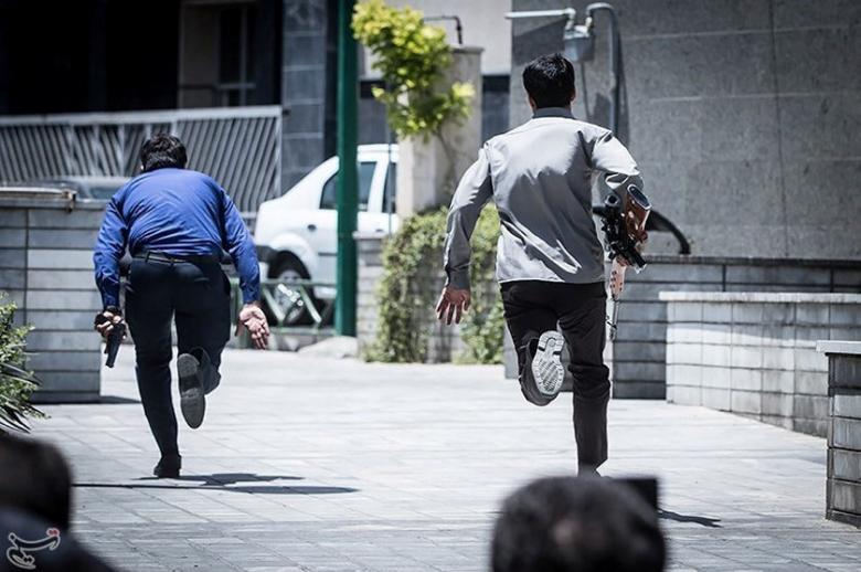 Members of Iranian forces run during an attack on the Iranian parliament in central Tehran, Iran.