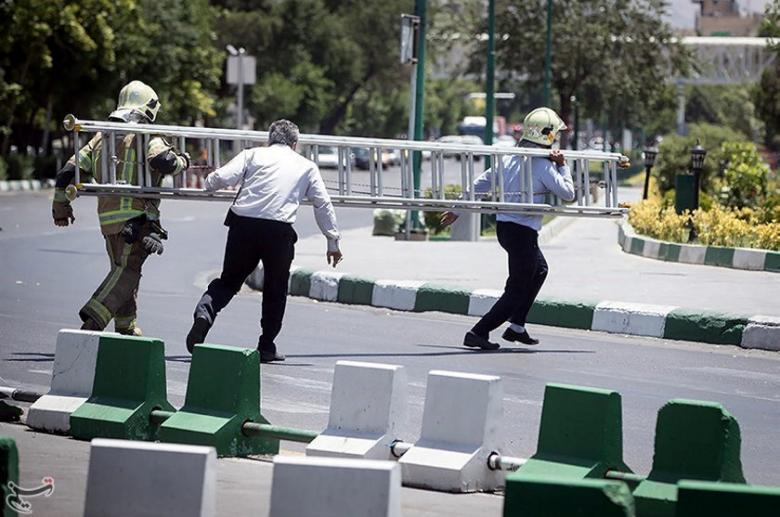 Members of Iranian civil defence run during an attack on the Iranian parliament in central Tehran, Iran.