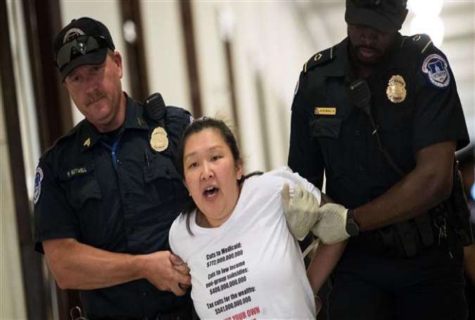 US Capitol Police arrest a protester demonstrating against the US Senate Republican health care bill, outside the office of US Senator Patrick Toomey, Republican of Pennsylvania, on Capitol Hill in Washington, DC, June 28, 2017. (Photo by AFP)