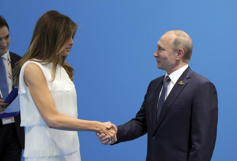 Russian President Vladimir Putin shakes hands with U.S. first lady Melania Trump during a meeting on the sidelines.