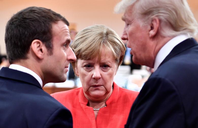 French President Emmanuel Macron, German Chancellor Angela Merkel and U.S. President Donald Trump confer at the start of the first working session.