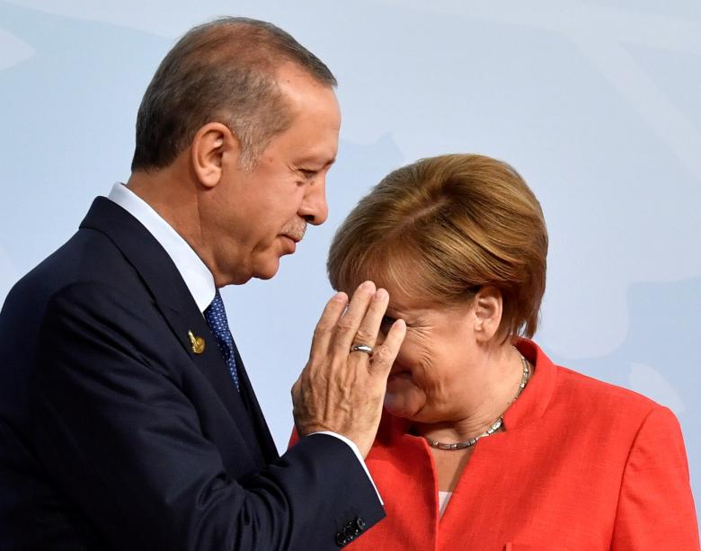 German Chancellor Angela Merkel greets Turkey's President Recep Tayyip Erdogan at the beginning of the G20 summit.