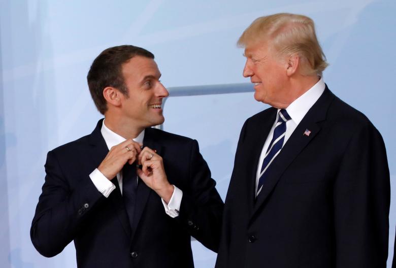 U.S. President Donald Trump looks at French President Emmanuel Macron before a family photo.