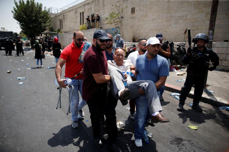 Palestinians carry a person during clashes with Israeli security forces outside Jerusalem