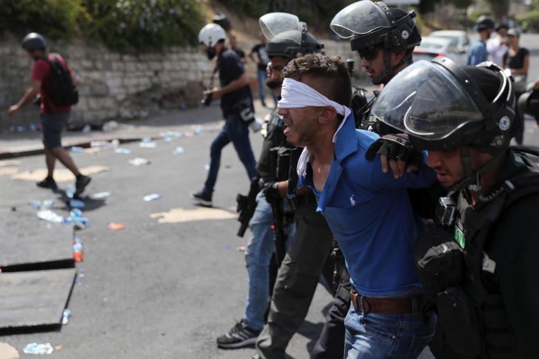 Israeli security forces arrest a Palestinian man following clashes outside Jerusalem