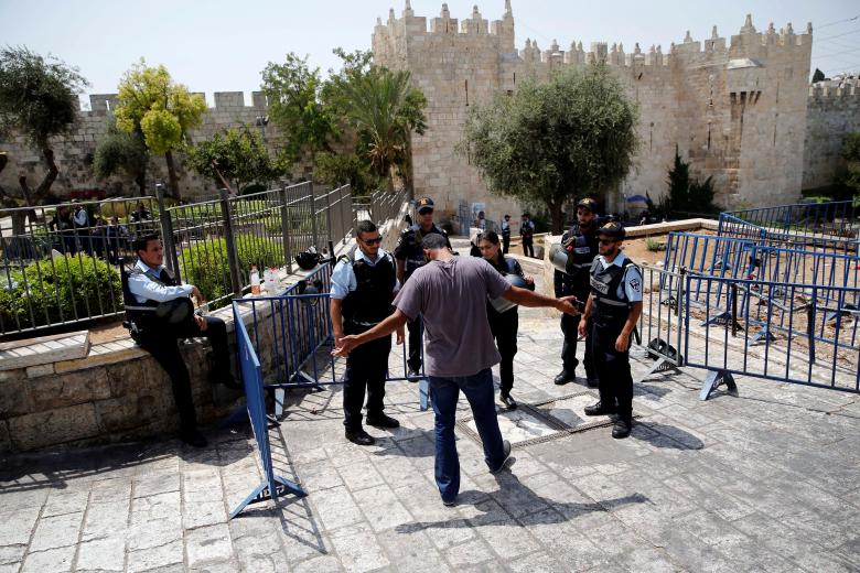 Israeli police check a Palestinian man at the entrance to Jerusalem