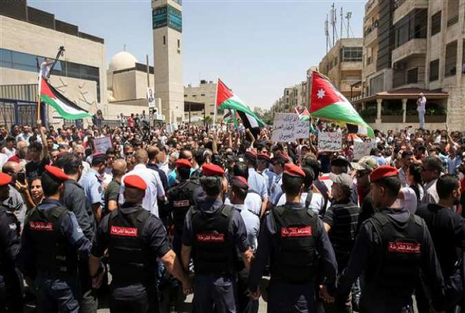 Jordanian security forces (foreground) stand guard before protesters as they wave national flags and chant slogans against Israel during a demonstration near the Israeli embassy in Amman, Jordan, on July 28, 2017. (Photo by AFP)