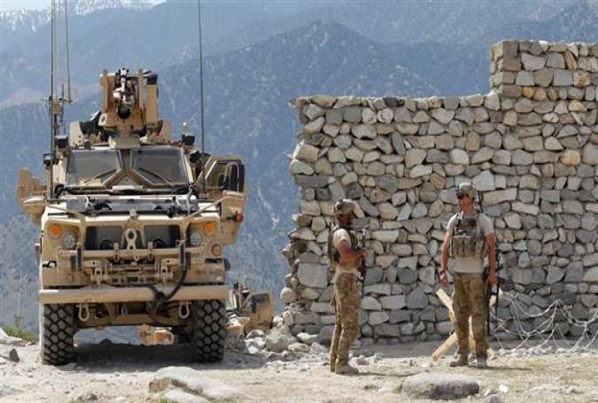 A file photo of US soldiers standing guard near the site of a US bombing in the Achin district of Nangarhar province in eastern Afghanistan April 15, 2017 (By Reuters)