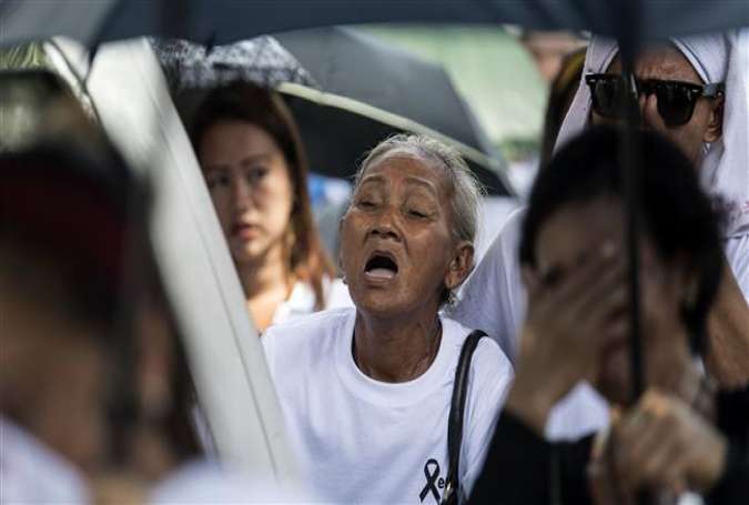 Elvira Miranda (C), mother of Leover Miranda, an alleged drug dealer who was killed on August 3, 2017, cries during the burial of Leover at the Manila North Cemetery on August 20, 2017. (Photo by AFP)