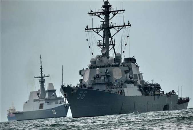 The guided-missile destroyer USS John S. McCain (R), with a hole on its portside after a collision with an oil tanker, is escorted by Singapore Navy RSS Intrepid to the Changi naval base in Singapore, on August 21, 2017. (Photo by AFP)