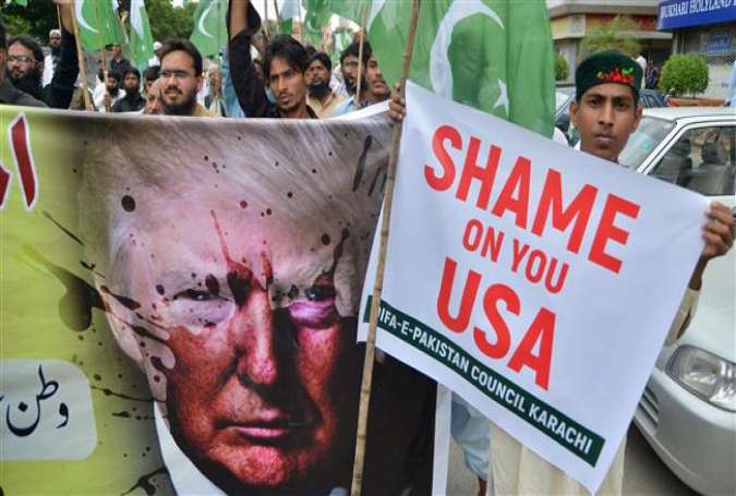 The supporters of the Defense of Pakistan Council, a coalition of around 40 religious and political parties, carry banners during a protest against US President Donald Trump, in Karachi, on August 25, 2017. (Photo by AFP)