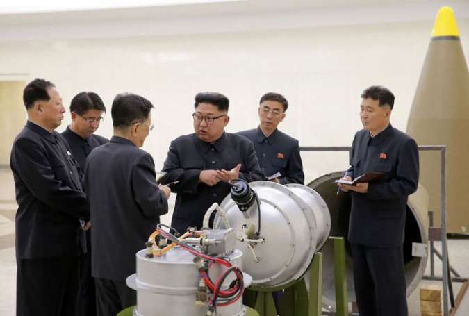 Pemimpin Korut Kim Jong Un (tengah) sedang melihat pipa logam di tempat yang tak diketahui.(REUTERS/KCNA)