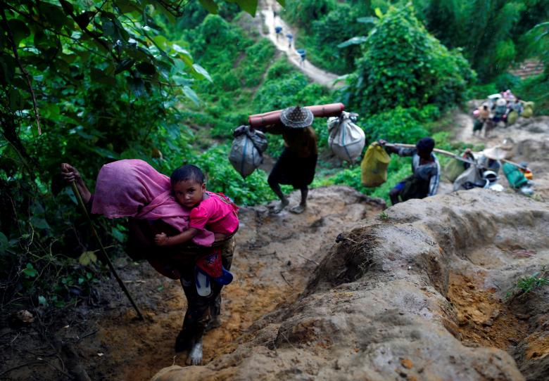 Rohingya refugees climb up a hill after crossing the Bangladesh-Myanmar border in Cox's Bazar, Bangladesh.