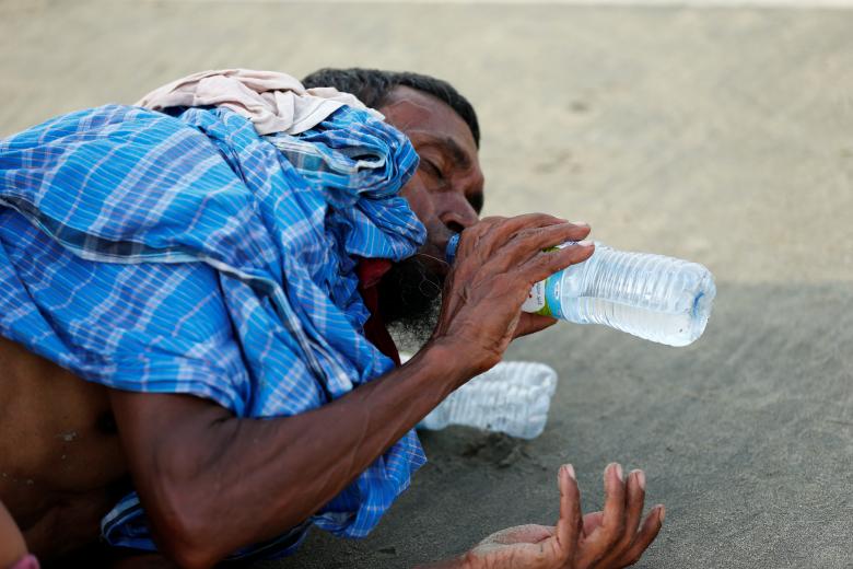 A Rohingya refugee man drinks water after crossing the Bangladesh-Myanmar border by boat through the Bay of Bengal in Teknaf, Bangladesh.