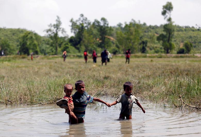 Rohingya children make their way through water as they try to come to the Bangladesh side from No Man�s Land after a gunshot being heard on the Myanmar side, in Cox's Bazar, Bangladesh.