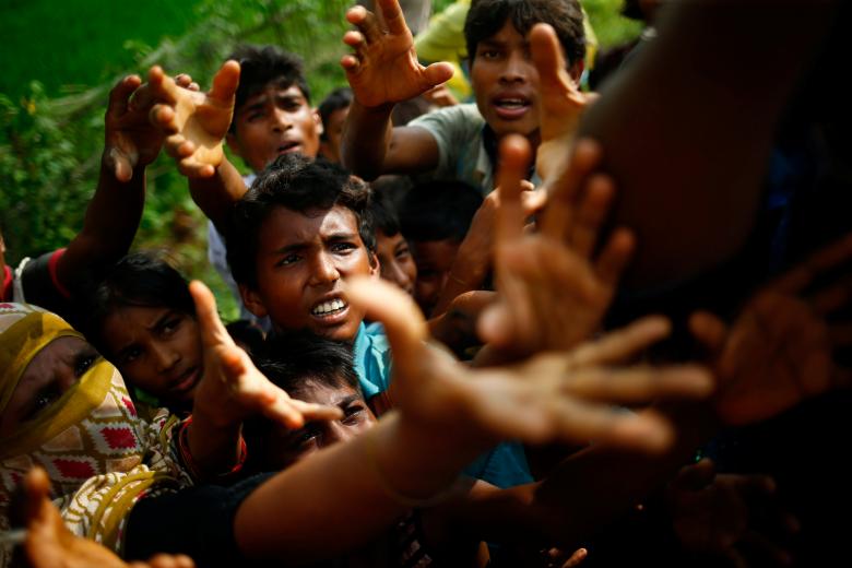Rohingya refugees stretch their hands for food near Balukhali in Cox's Bazar, Bangladesh.