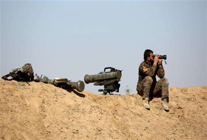 A fighter of the US-backed Syrian Democratic Forces (SDF) looks with binoculars as he sits next to anti-tank weapons in the village of Sabah al-Khayr on the northern outskirts of Dayr al-Zawr, Syria, February 21, 2017. (Photo by AFP)
