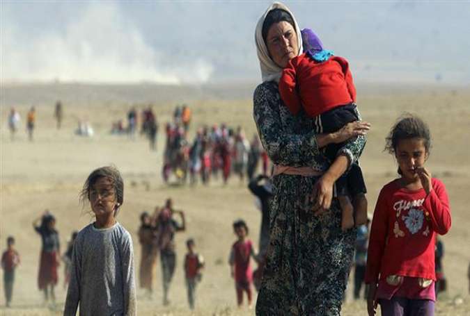 Displaced Yezidis, fleeing violence from Daesh terrorists, head toward the Syrian border in August 2014.