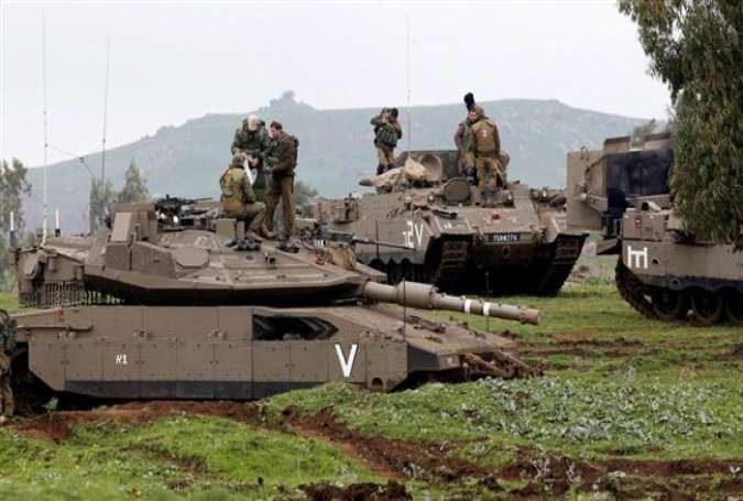 File photo shows Israeli soldiers standing on top of a tank (front) and an armored personnel carrier as they take part in an exercise in the occupied Golan Heights. (Photo by Reuters)