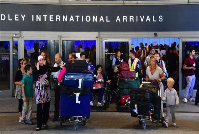 People exit the International Arrivals section at Los Angeles International Airport on June 29, 2017, where they were met by activists protesting President Donald Trump