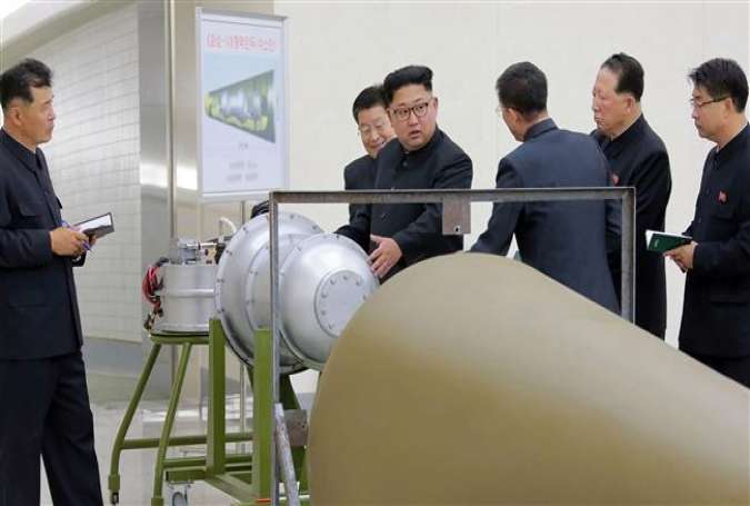 This picture released by North Korea’s official Korean Central News Agency (KCNA) on September 3, 2017 shows North Korean leader Kim Jong-un (C) looking at a metal casing with two bulges. (Via AFP)