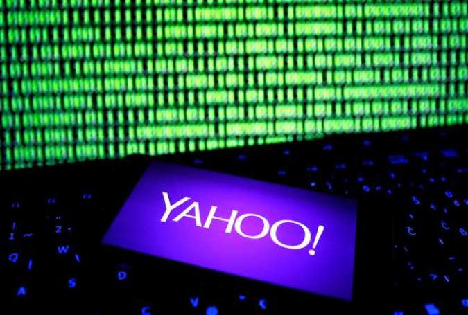 A photo illustration shows a Yahoo logo on a smartphone in front of a displayed cyber code and keyboard on December 15, 2016. (By Reuters)