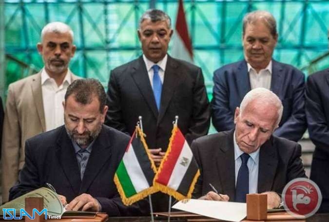 Head of Hamas delegation Saleh Arouri (left) and Fatah leader Azzam al-Ahmad (right) sign a reconciliation deal in Cairo