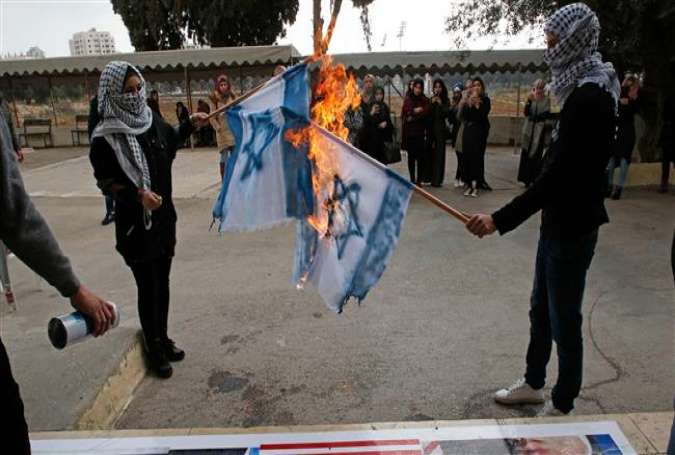 Palestinian protesters burn Israeli flags during a demonstration at the Jerusalem al-Quds Open University in Dura village on the outskirts of the West Bank town of al-Khalil (Hebron) on December 13, 2017. (Photo by AFP)