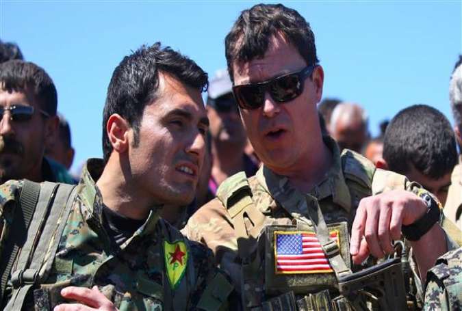 The photo, taken on April 25, 2017, shows a US officer from the coalition led by Washington speaking with a fighter from the Kurdish People