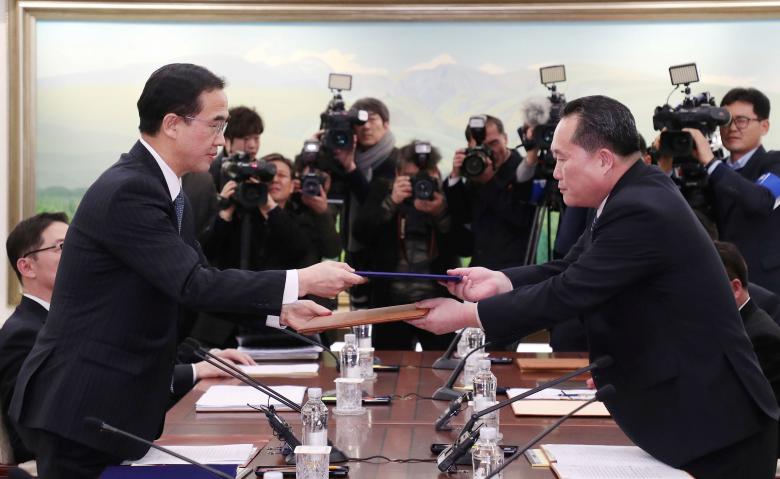 Head of the North Korean delegation, Ri Son Gwon exchanges documents with South Korean counterpart Cho Myoung-gyon after their meeting at the truce village of Panmunjom in the demilitarized zone separating the two Koreas, South Korea.