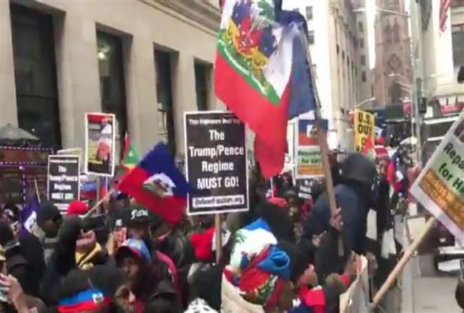 Hundreds of protesters chant against US President Donald Trump and ask for reparations for Haiti outside The Trump Building at 40 Wall Street on Friday, January 19 in New York City.