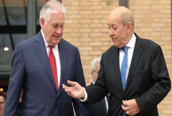 French Foreign Minister Jean-Yves Le Drian (R) gestures to US Secretary of State Rex Tillerson as they arrive for a group photograph during a meeting of diplomats on chemical attacks in Syria, in Paris on January 23, 2018. (Photo by AFP)