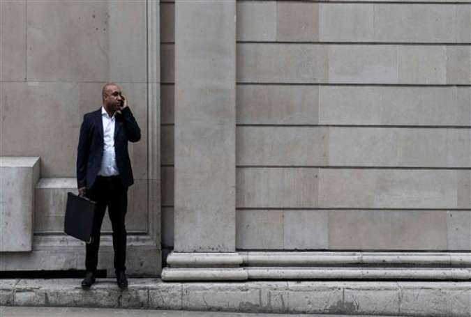 A businessman stands and speaks on his mobile phone outside the Bank of England in London on March 29, 2017. (Photo by AFP)