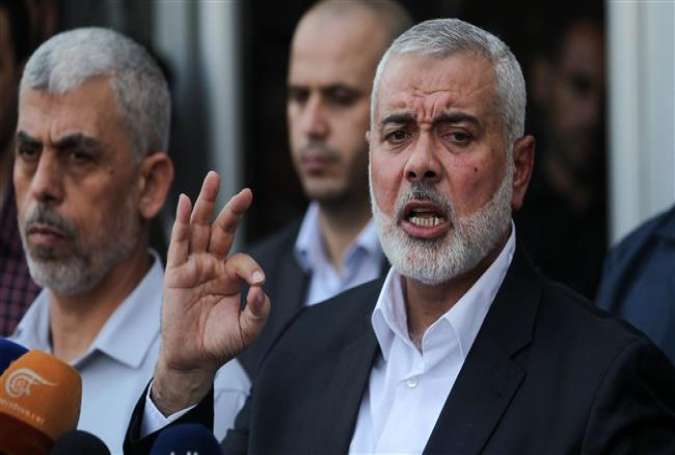 Hamas Chief Ismail Haniyeh (R) speaks to the press upon his arrival on the Palestinian side of the Rafah border crossing, in the southern Gaza Strip on September 19, 2017. /(Photo by AFP)