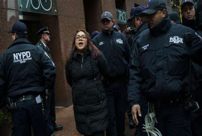 After blocking the doors to the building, an activist is arrested by members of the New York City Police Department. (Photo by AFP)
