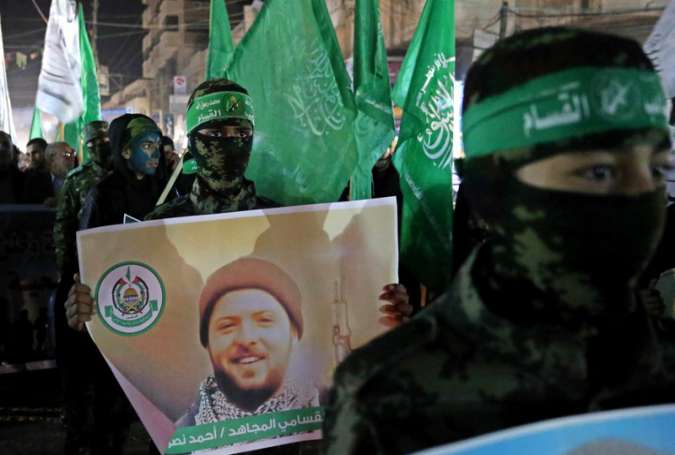 Hamas resistance fighters carry posters of martyr Ahmad Nasser Jarrar