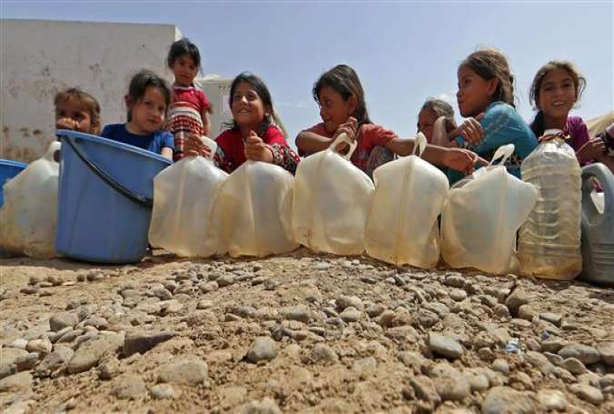 Displaced Iraqi children wait in line for water rations at the Hamam al-Alil camp, south of Mosul on May 26, 2017. (Photo by AFP)