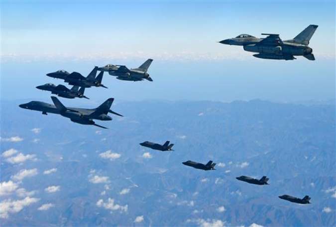 This handout picture, taken and released by the South Korean Defense Ministry in Seoul on December 6, 2017, shows a US Air Force B-1B Lancer bomber (L), two US F-35As, and two US F-35B stealth jets (far) flying over South Korea. (Via AFP)