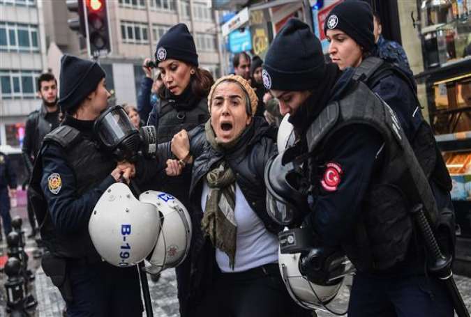 A woman reacts as Turkish police officers arrest her during a demonstration called by the Peoples