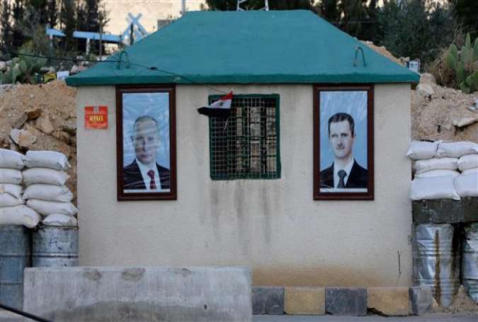 A picture taken on February 28, 2018 shows the portraits of Syrian President Bashar al-Assad (R) and Russian President Vladimir Putin hanging outside a guard-post at the Wafideen checkpoint on the outskirts of Damascus neighboring the terrorist-held Eastern Ghouta region. (Photo by AFP)