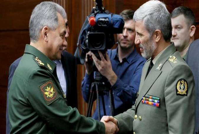 The handout image made available by the Russian Defense Ministry shows Russian Defense Minister Sergei Shoigu (L) shaking hands with his Iranian counterpart, Brigadier General Amir Hatami, during a meeting in Moscow, Russia, April 3, 2018. (Via Reuters)