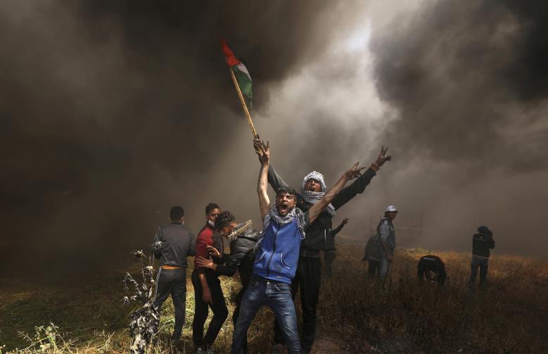 Palestinian demonstrators shout during clashes with Israeli troops at a protest demanding the right to return to their homeland, at the Israel-Gaza border east of Gaza City April 6, 2018.