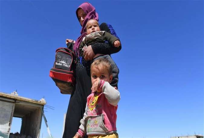 Displaced Syrian families arrive at a checkpoint at Abu al-Duhur crossing to return from militant-held areas in Syria