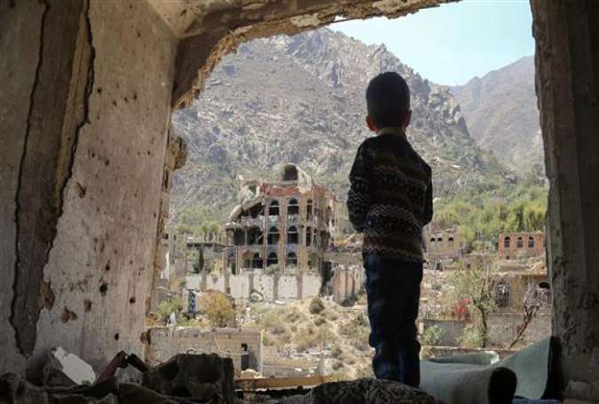 Pictue taken on March 18, 2018, shows a Yemeni child looking out at buildings that were damaged in an airstrike in the southern Yemeni city of Ta