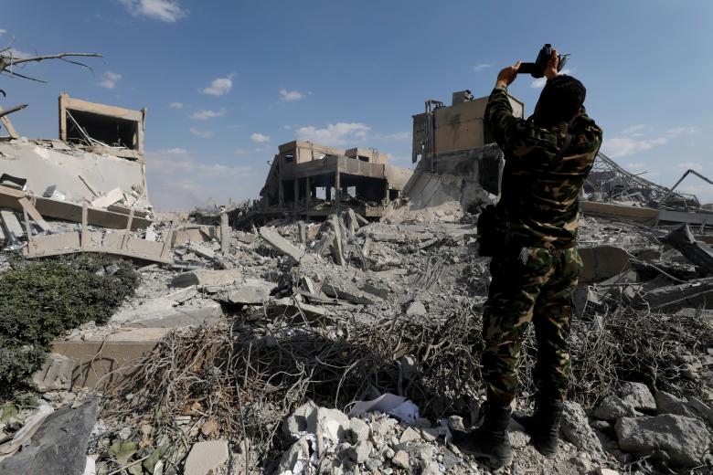 A Syrian military officer records a video inside the destroyed Scientific Research Centre in Damascus, Syria April 14, 2018.
