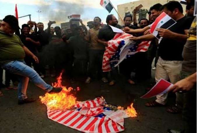 تظاهرات گسترده عراقی‌ها در بغداد در محکومیت حمله به سوریه/ پرچم آمریکا به آتش کشیده شد