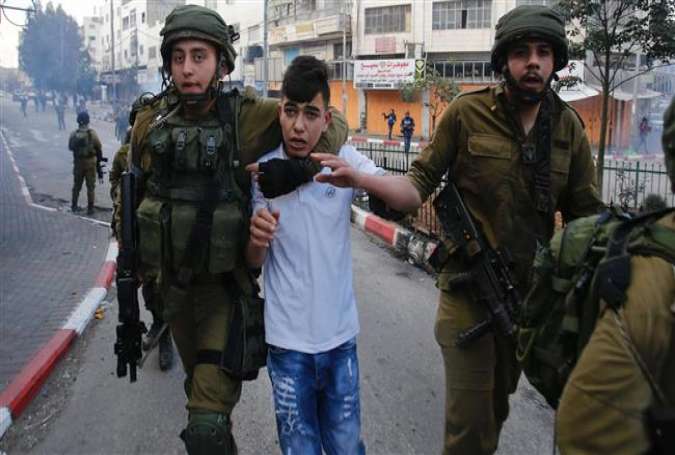 Israeli soldiers detain a Palestinian boy during clashes at a protest rally in the West Bank city of al-Khalil (Hebron), December 15, 2017. (Photo by AP)