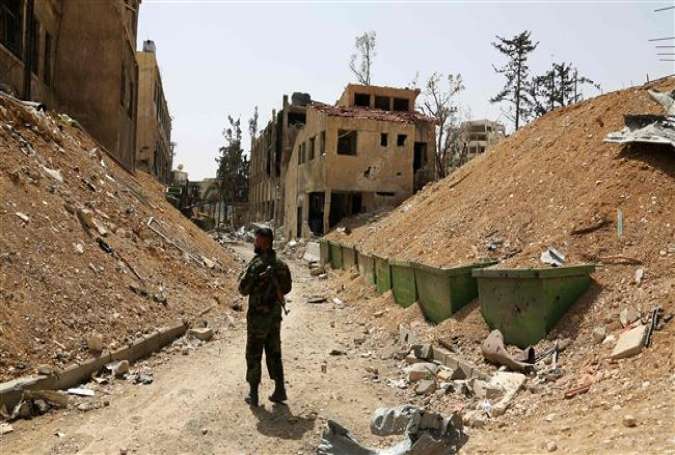 A Syrian soldier walks down a destroyed street in the former militant-held Syrian town of Douma on the outskirts of Damascus on April 19, 2018, five days after the Syrian army declared that all anti-government forces have left Eastern Ghouta, following a blistering two month offensive on the militant-held enclave. (Photo by AFP)
