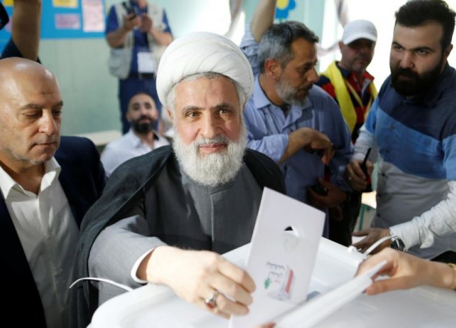 Hezbollah deputy leader Sheikh Naim Qassem casts his vote as he stands next to Hezbollah parliament candidate Amin Sherri at a polling station during the parliamentary election, in Beirut, Lebanon,